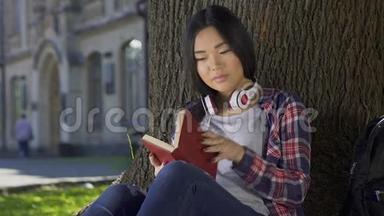亚洲女孩阅读书章，热情微笑，喜欢<strong>情节</strong>，爱好