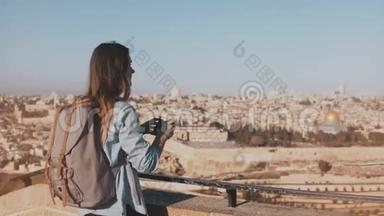 女游客拍摄耶路撒冷古镇照片.. 漂亮的白人旅行者女人带着背包微笑。 以色列。 4K.