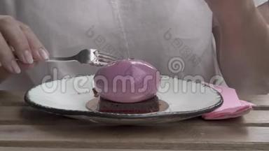 一种特写，一个女人在前台吃的蛋糕。 一个女人`手拿着一块巧克力，用餐巾擦手