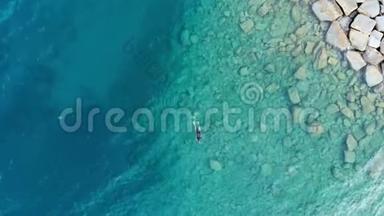 空中：一名潜水员在清澈的地中海、深蓝色的透明水域游泳，暑假c