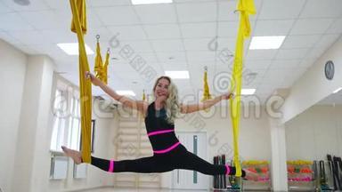 年轻美丽的<strong>瑜伽</strong>女子在健身俱乐部的<strong>紫色</strong>吊床上做空中<strong>瑜伽</strong>练习