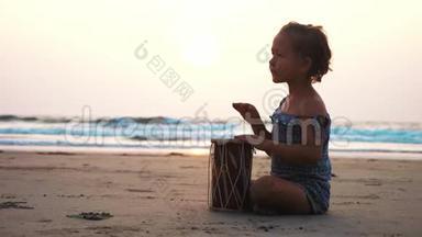 可爱的小女孩在沙滩上<strong>打鼓</strong>。