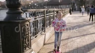 夏天，小孩子在公园里骑滑板车。 可爱的女孩在户外玩耍。 主动休闲和儿童户外运动。