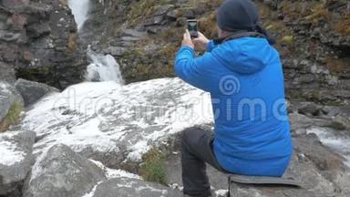 一个穿着运动服的人，在瀑布附近休息。 3.他在山上拍了一幅美丽的风景画