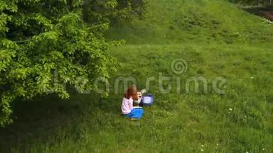 一个年轻漂亮的女孩，带着科吉狗<strong>坐在树下</strong>的草地上