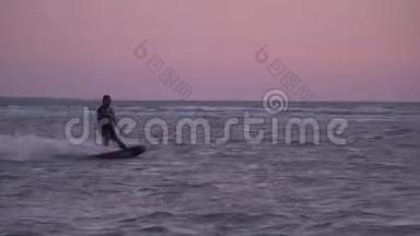 一个穿着潜水服的人在黎明时管理训练风筝