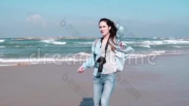 美丽的欧洲女人走在阳光明媚的海滨。漂亮女孩微笑着看着镜头。风<strong>吹拂</strong>着头发。慢动作
