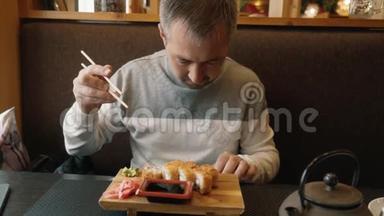 男人学会用筷子做寿司。 那个人看了看寿司棒上的指示。 哈希，筷子