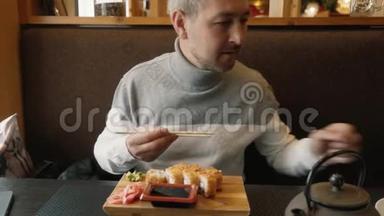 男人学会用<strong>筷子</strong>做寿司。 那个人看了看寿司棒上的指示。 哈希，<strong>筷子</strong>