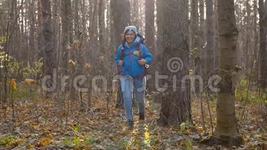 概念冬<strong>季</strong>，秋<strong>季旅游</strong>和徒步旅行.. 一个年轻的徒步旅行者在秋天的森林里徒步旅行