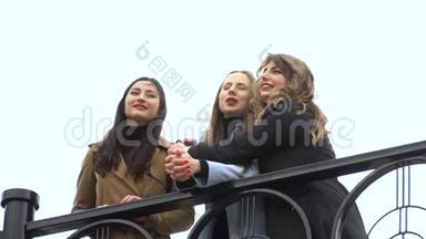 女孩的友谊。 三个年轻漂亮的女孩在街上聊天。 他们很开心。 女孩们很高兴认识