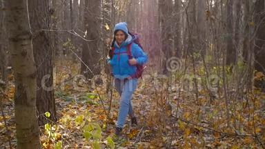 概念冬季，秋季旅游和徒步旅行.. 一个年轻的徒步旅行者在秋天的森林里徒步旅行