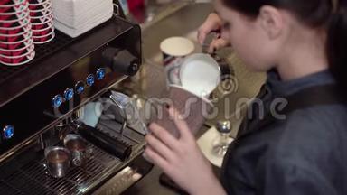 女咖啡师准备将牛奶倒入纸杯中，加入咖啡，并在牛奶上画在牛奶上