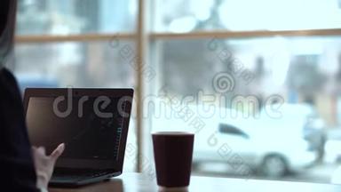 布鲁内特女孩在笔记本电脑上跟踪交易记录，经常喝咖啡