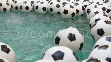 许多黑白足球背景。 足球球在纯净水中游泳。 雨水从高空落下