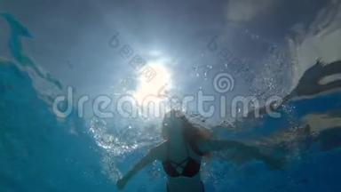 在干净的蓝色<strong>游泳</strong>池里的女人在充满活力的环境中，在背景气泡上睁开眼睛在水下<strong>游泳</strong>