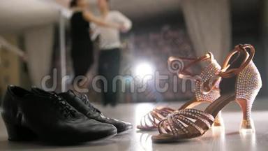 模糊的职业男女<strong>舞蹈</strong>拉丁舞服装在<strong>工作室</strong>，两双舞厅鞋在前景