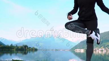 一位迷人的年轻女子在做一个瑜伽姿势，以保持平衡，并在Zellam湖附近伸展