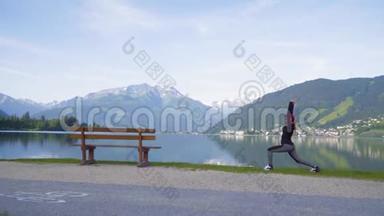 一位迷人的年轻女子在做一个瑜伽姿势，以保持平衡，并在Zellam湖附近伸展