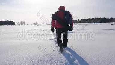 人雪冬的脚印.. 概念之旅克服困难。 日落时分的冬夜平原上的徒步旅行者