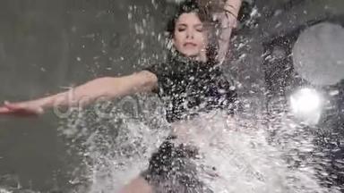 湿漉漉的女舞蹈演员在雨中<strong>跳跃</strong>，<strong>溅起水花</strong>。 跳舞的女孩在下面跳舞