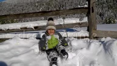 冬天，小可爱的男孩在外面的雪地里玩耍。 背景是一片雪林.. 这个男孩很高兴。