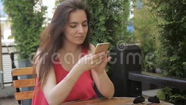 优格女士坐在舒适的<strong>街头</strong>咖啡馆里，在智能手机上打字的<strong>照片</strong>。