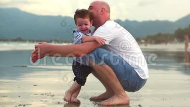 年轻的家庭，父亲和儿子，一个快乐的儿子拥抱他的父亲在海岸。 幸福的家庭，沿着海岸散步。