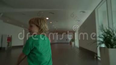 一个小男孩手里拿着白色玩具飞机，在机场里奔跑的慢镜头。 自由概念