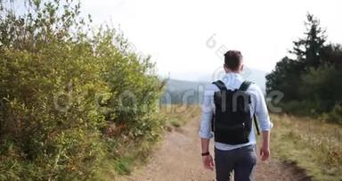 孤独地走在山里。 一个人走在路上，走在一座山上，前面有一片壮丽的风景，他看着自己