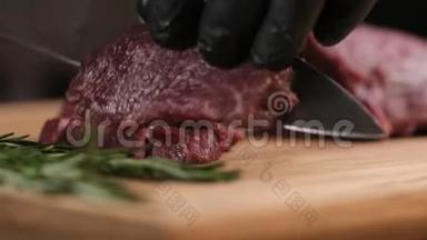 餐厅厨房的厨师在木板上切肉. 桌子上摆着青菜和樱桃番茄