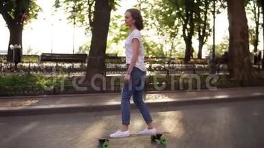 公园日出时穿着蓝色牛仔裤和白色运动鞋的年轻女人在滑板。 滑板上的腿。 慢镜头