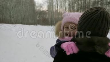 女孩跑到妈妈身边，在冬天的森林里拥抱她