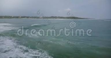 无人机照相机左转，跟随巨大的海浪到达宁静的热带海滩，并与美丽的泡沫碰撞。