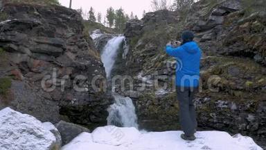 一个穿着运动服的人，在瀑布附近休息。 3.他在山上拍了一幅美丽的<strong>风景画</strong>