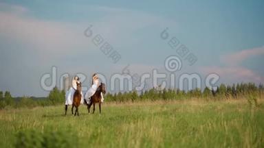 两个穿着白色连衣裙的女孩骑马。 女孩们骑马在田野上跳跃。 慢动作。