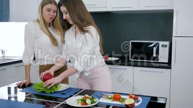女孩准备新鲜蔬菜沙拉和朋友在家厨房，适当的营养和饮食