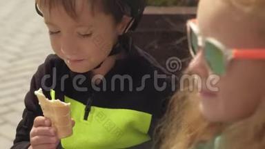 一个男孩和一个女孩坐在公园的长凳上吃冰淇淋。 夏季