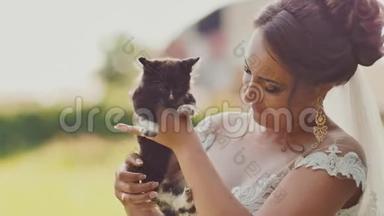 迷人的黑发新娘手里抱着一只小猫。 婚礼的那一刻。
