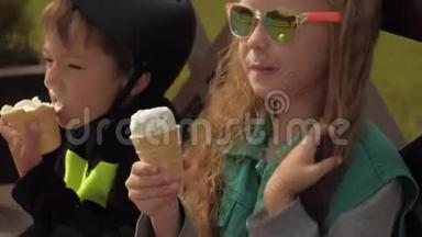 一个男孩和一个女孩坐在公园的长凳上吃冰淇淋。 夏季