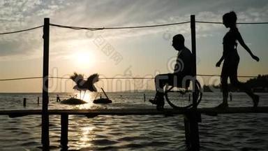 身材魁梧的女人，男人残疾人坐在轮椅上，在余晖下的堤岸与天堂<strong>决裂</strong>