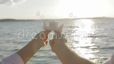 纸船在恋人手中飘浮在阳光普照的小路上