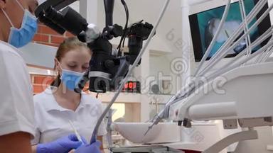 戴着橡胶手套的男人在显微镜下观察，旁边是戴着医用口罩的女医生