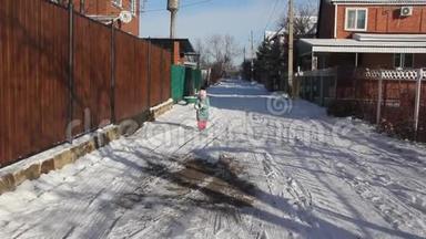冬天。 一个小孩在雪地街上跑来跑去