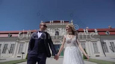 美丽的年轻<strong>新娘</strong>和她英俊的新郎在贝维迪尔宫散步。 高清<strong>视频</strong>