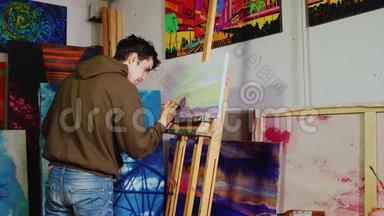 年轻英俊的画家在工作室工作。 绘制典型的<strong>美国乡村</strong>景观