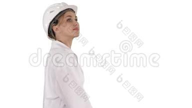 戴着安全帽的年轻女子在白色背景下<strong>走来走</strong>去。