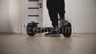 在带有白色墙壁的公寓里，男腿在电动陀螺滑板车上走动，然后走开的特写镜头。