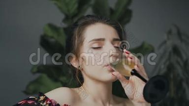 一个在浴室喝香槟的可爱年轻女人的肖像。 年轻的美女喝香槟放松