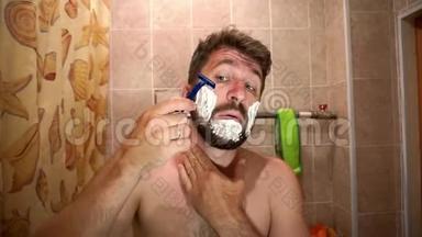 有胡子的男人用一把安全剃刀刮胡子